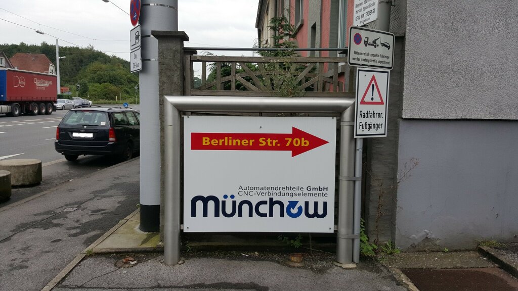 Einfahrt mit Schild zum Hof der Münchow GmbH.